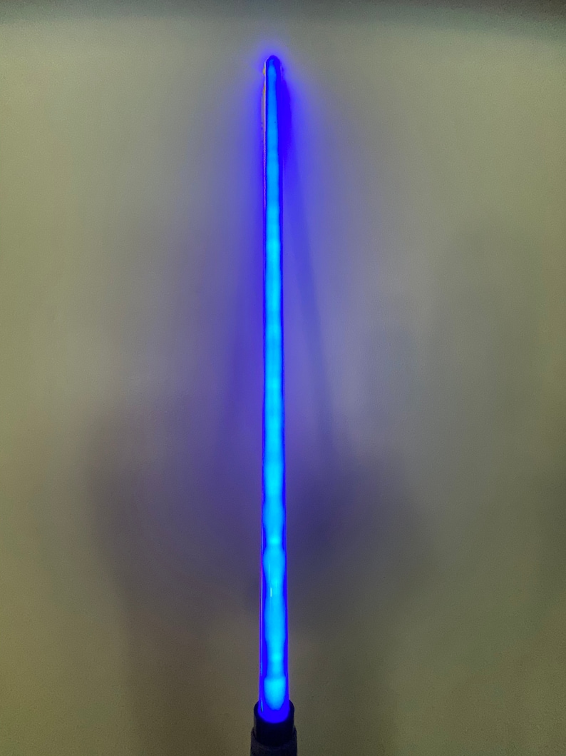 以下が含まれることがあります： 白い柄の青いライトセーバーのおもちゃ