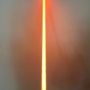 以下が含まれることがあります： 黒い柄の長いオレンジ色のライトセーバー