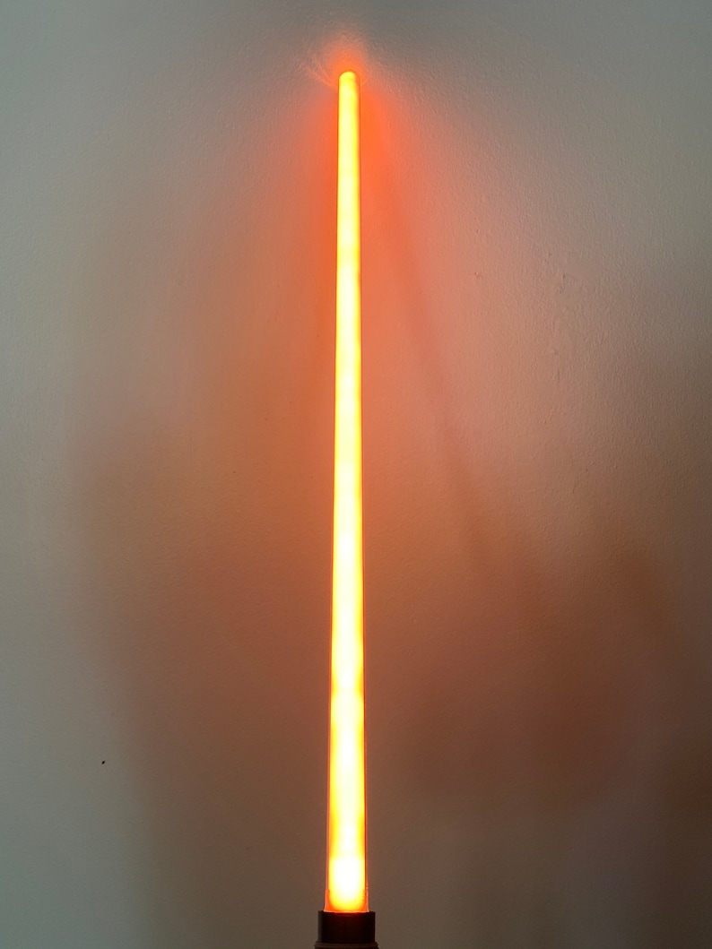 以下が含まれることがあります： 黒い柄の長いオレンジ色のライトセーバー