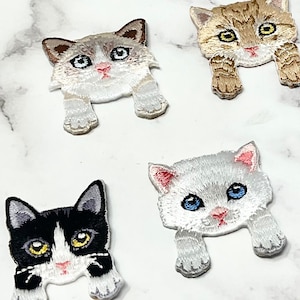 Può includere: Un set di dieci toppe ricamate da stirare che presentano vari gatti carini in diversi colori e pose. Le toppe sono perfette per aggiungere un tocco di fantasia a vestiti, borse o altri oggetti in tessuto.