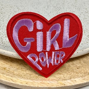 May include: Red heart-shaped embroidered patch with the words "Girl Power" in purple lettering.