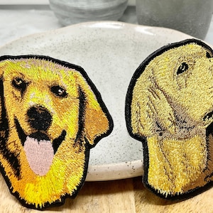 Peut inclure: Deux patchs brodés de chiens golden retriever. Un patch montre un chien avec sa langue qui sort, l'autre montre un chien regardant sur le côté.