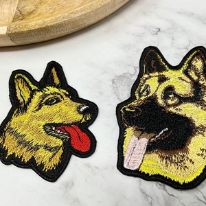 Peut inclure: Deux patchs brodés de chiens de berger allemand. Un patch est jaune avec une langue rouge et l'autre est brun et jaune avec une langue rose.
