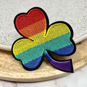 Peut inclure: Patch brodé en forme de trèfle arc-en-ciel. Le trèfle est en feutre et a un contour noir.