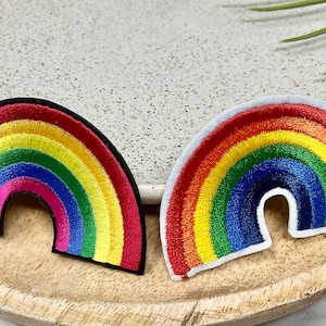 May include: Two rainbow embroidered patches, one with a black border and one with a white border. Both patches feature a rainbow design with red, orange, yellow, green, blue, indigo, and violet colours.