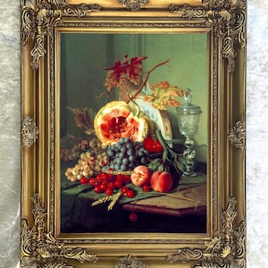 May include: A framed still life painting featuring a variety of fruits, including grapes, cherries, and peaches. The painting has a gold ornate frame. The fruits are arranged on a table with a green tablecloth, and a glass with a lid is also present.