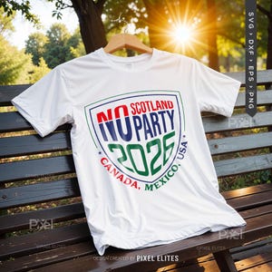 Puede incluir: Una camiseta blanca con un dise&ntilde;o de escudo que dice "NO SCOTLAND PARTY 2026" en rojo, azul y verde. Las palabras "CANADA, MEXICO, USA" est&aacute;n en un patr&oacute;n circular alrededor del escudo. La camiseta est&aacute; colgada en una percha de madera.