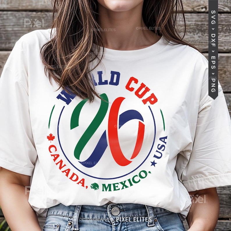 May include: White t-shirt with a colorful graphic design for the 2026 World Cup. The design includes the text "WORLD CUP 26" in blue, green, and red, with "CANADA, MEXICO, USA" in a circular arrangement.