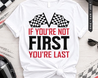 May include: A white short-sleeve t-shirt featuring two black and white checkered racing flags at the top. The text reads IF YOU'RE NOT FIRST YOU'RE LAST in a combination of bold red and black lettering centered on the front of the garment.