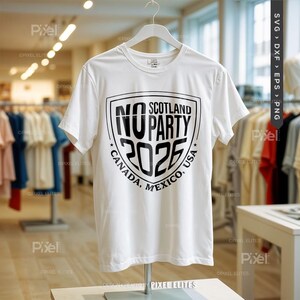 Puede incluir: Una camiseta blanca con un dise&ntilde;o gr&aacute;fico negro. El dise&ntilde;o presenta las palabras "NO PARTY 2026" dentro de un escudo, con "SCOTLAND" arriba y "CANADA, MEXICO, USA" abajo. La camiseta se exhibe en una percha en un entorno comercial.