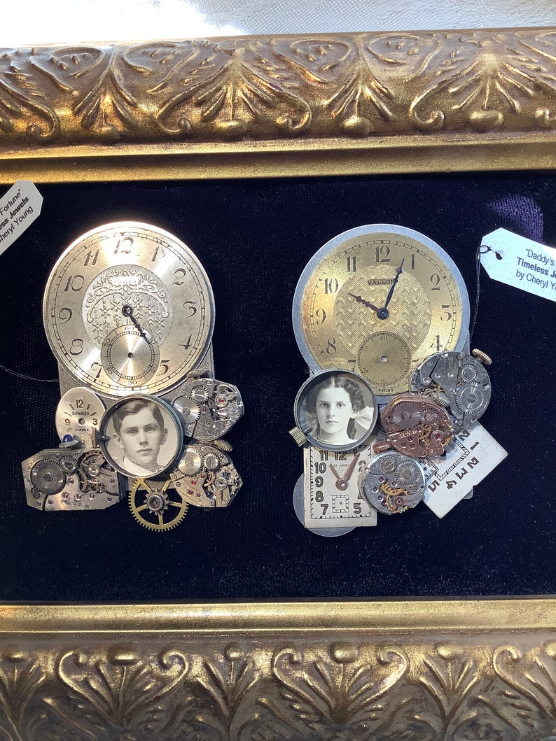 May include: A framed artwork featuring two vintage pocket watches with gears and a small photo of a young woman and a young man. The artwork is titled "Daddy's Timeless Jewels by Cheryl Young".