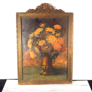 May include: An antique framed floral still life painting. The artwork features a bouquet of yellow, orange, and brown flowers in a gold-toned vase. The frame is ornate with a gold finish and decorative details.