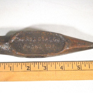 May include: A rusty metal hammer with a pointed head and a handle. The hammer is about 5 inches long and has the text "THE CROSBY" stamped on the side.