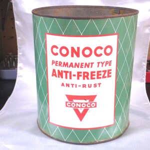 May include: A vintage metal can of Conoco Permanent Type Anti-Freeze with Anti-Rust. The can is green with a white label and red text. The label features a red triangle with the Conoco logo.