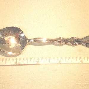 Cuchara para condimentos con diseño Interlude de International Silver Plate Co.
