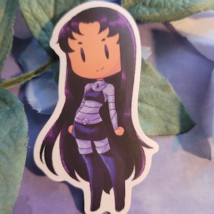 May include: A sticker featuring a cartoon character with long black hair, wearing a purple and white outfit. The character has a purple and white outfit and a light blue gem on their chest.