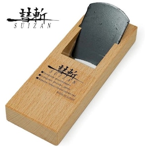 Puede incluir: Un cepillo de mano de madera con una cuchilla de metal negro. El cepillo está etiquetado como "Suizan" en caracteres japoneses e inglés. El cepillo está hecho en Japón.