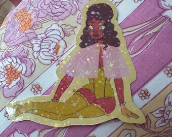 May include: A sticker featuring a seated cartoon figure with red skin, curly brown hair, and a pink cape adorned with stars. The figure wears a yellow corset, stockings, and red garter. The sticker has a holographic finish and is set against a floral background.