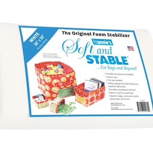 May include: White foam stabilizer sheet, 36 inches by 58 inches, for bags and beyond. The sheet is shown rolled up. The packaging shows a red and white patterned fabric with the text "Soft and Stable by Annie's".