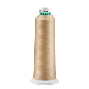 May include: A spool of Madeira thread in a light beige color. The spool is labeled "Madeira" and "907".