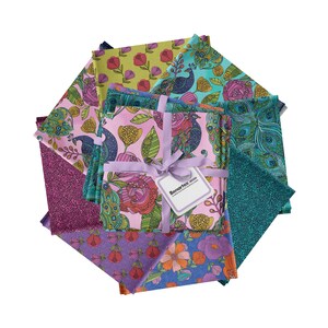 May include: A collection of colorful fabric squares with floral and peacock designs. The fabrics are in shades of pink, purple, green, and blue, tied together with a lavender ribbon and a tag that reads "Benartex".