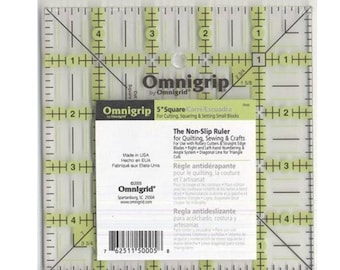 May include: A clear plastic 5-inch square Omnigrip ruler with yellow markings. The ruler is designed for quilting, sewing, and crafts. It features a non-slip surface and a diagonal line for triangle cuts. The text on the ruler reads "Omnigrip by Omnigrid", "5" Square", "The Non-Slip Ruler", "Règle antidérapante", and "Regla antideslizante".