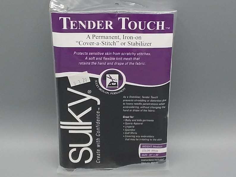 K&ouml;nnte beinhalten: Eine wei&szlig;e Verpackung mit einem violetten Etikett, auf dem "Tender Touch&trade;" steht. Ein permanentes, aufb&uuml;gelbares "Cover-a-Stitch" oder Stabilisator. Das Etikett zeigt auch "Sulky&trade; Create with Confidence" und listet das Gewicht, die Farbe und die Gr&ouml;&szlig;e des Produkts auf.