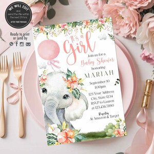 Puede incluir: Una invitación de baby shower rosa y verde con un elefante de dibujos animados sosteniendo un globo rosa. La invitación dice "It's a Girl" e incluye el nombre Mariah, la fecha y la hora de la ducha, y la dirección. También incluye información de registro para Amazon y Target.