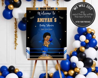 May include: A black and gold welcome sign for a baby shower with a blue boxing ring and a cartoon baby boxer. The sign says "Main Event: Welcome to Amiyah's Baby Shower May 22th 20XX".