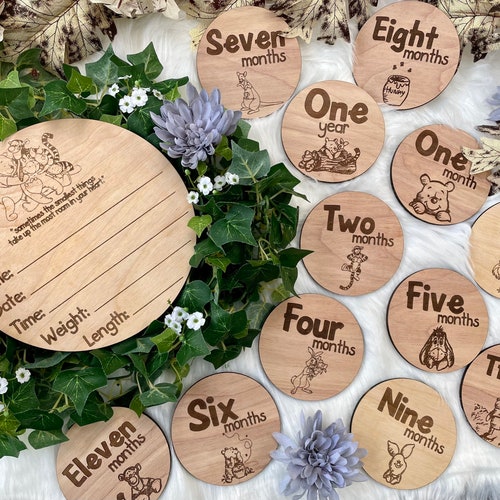 Letrero de madera de Winnie the Pooh para anunciar el nacimiento y marcadores de fotos mensuales para los hitos del embarazo.