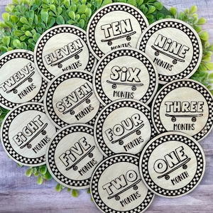 May include: Twelve wooden circles with black and white chequered borders. Each circle features a number from one to twelve with the word "MONTHS" written below. A skateboard graphic is included on each circle.