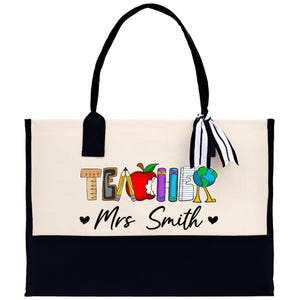 a black and white bag with a teacher's apple on it