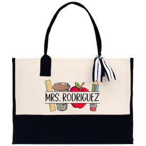 a black and white bag with a picture of a teacher's apple
