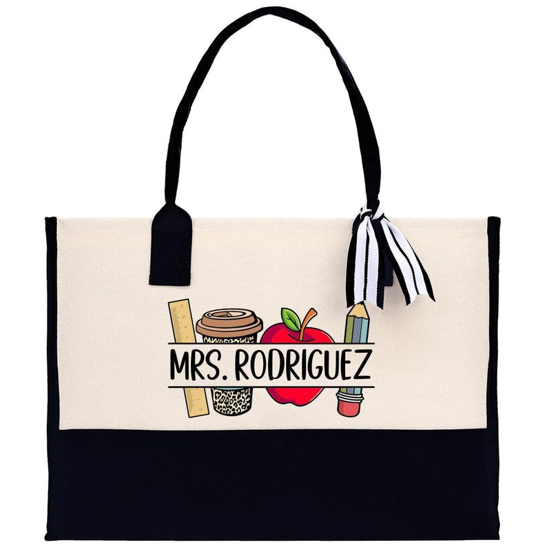 a black and white bag with a picture of a teacher's apple