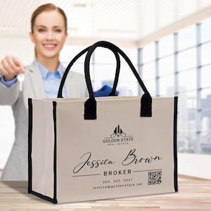 Op de afbeelding: Beige canvas draagtas met zwarte randen en handvatten. De tas toont de tekst "Golden State Real Estate" en de naam "Jessica Brown, Broker" in zwart schrift. Een QR-code en contactgegevens zijn ook zichtbaar.