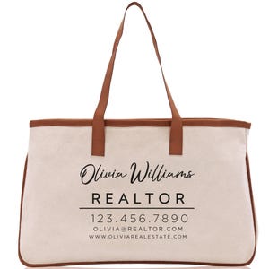 a white canvas bag with a brown leather handle