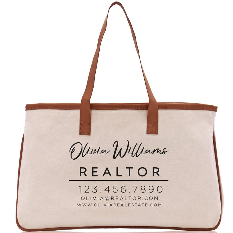 a white canvas bag with a brown leather handle