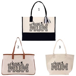a black and white tote bag with the word'cheer mom'printed on