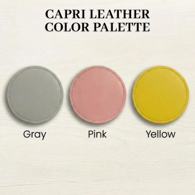 three circular leather coasters with different colors: gray, pink, and yellow.