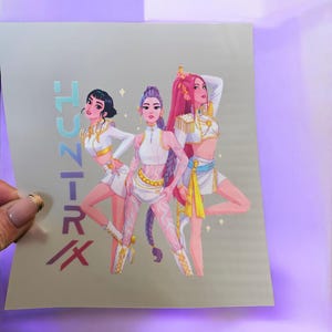 May include: Illustration of three women in white and gold outfits with long hair. The image has the text "TUNE-IRX" in blue and red. The women are in a dynamic pose with a light grey background.