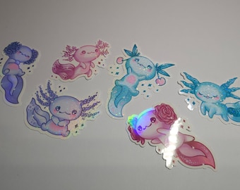 May include: Six iridescent axolotl stickers with different poses and colors. The axolotls are all smiling and have glitter accents. The stickers are on a white background.