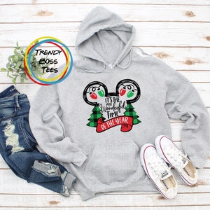 Puede incluir: Sudadera gris con capucha con un diseño en negro y verde con orejas de Mickey Mouse con luces de Navidad y el texto "Es la época más maravillosa del año".