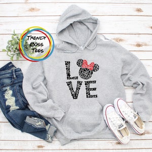 May include: Grey hooded sweatshirt with a black and white graphic of Mickey Mouse ears and the word "LOVE" spelled out with Mickey Mouse heads. The graphic has a red bow on top of the Mickey Mouse head.
