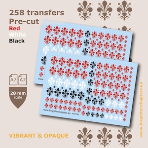May include: Two light blue sheets of pre-cut transfers with red, white, and black fleur-de-lis patterns. The sheets have the text "258 transfers", "Red", "White", "Black", and "VIBRANT & OPAQUE". The scale is 2.8 cm.