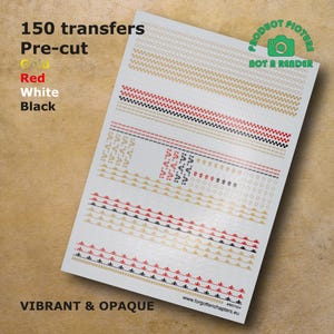 Puede incluir: Una hoja de 150 transferencias precortadas en dorado, rojo, blanco y negro. Las transferencias están dispuestas en filas y presentan varios diseños, incluyendo patrones geométricos, estrellas y motivos florales. La hoja está etiquetada "150 transferencias Precortadas Dorado Rojo Blanco Negro" y "VIBRANTE & OPACO".