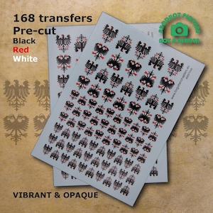 Può includere: Un foglio di 168 trasferimenti pretagliati con disegni di aquile nere, rosse e bianche. I trasferimenti sono etichettati "168 trasferimenti, Pretagliati, Nero, Rosso, Bianco, Vivaci e Opaco".