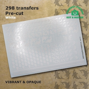 Op de afbeelding: Een vel met 298 witte, voorgeknipte transfers. De transfers zijn ondoorzichtig en levendig. Het vel is gelabeld met "298 transfers Voorgeknipt Wit" en "LEVENDIG & ONDOORZICHTIG".