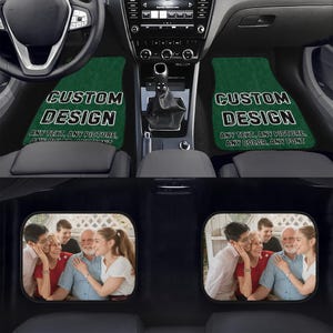 May include: Two green car floor mats with the text "CUSTOM DESIGN" and "ANY TEXT. ANY PICTURE. ANY COLOR. ANY FONT". The mats are in a car with two black headrests with images of a family.