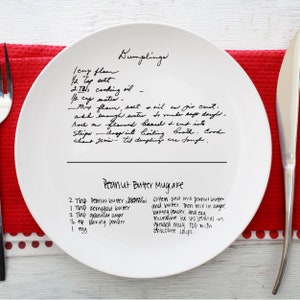 Puede incluir: Un plato blanco con recetas escritas a mano para albóndigas y pastel de taza de mantequilla de maní. Las recetas incluyen los ingredientes y las instrucciones para ambos platos.