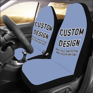 Puede incluir: Dos fundas para asientos de coche de color azul con ribetes negros. Las fundas tienen el texto "CUSTOM DESIGN" impreso en ellas. El texto est&aacute; en una fuente negra y desgastada. El texto tambi&eacute;n incluye la frase "ANY TEXT, ANY PICTURE, ANY COLOR, ANY FONT".